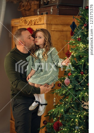 dad and little daughter at the Christmas tree. dad and little daughter at the Christmas tree. 123575376