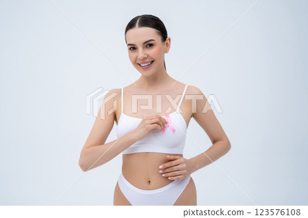 Smiling young woman holding a pink ribbon in hands 123576108