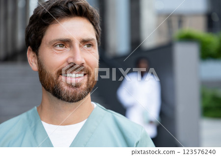 Young caucasian bearded doctor with a patient case in hands Young caucasian bearded doctor with a patient case in hands 123576240