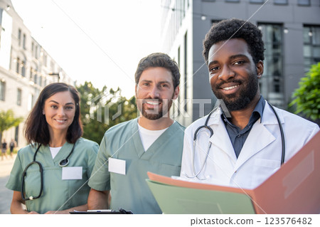 Group of doctors in lab coats looking positive and contented 123576482