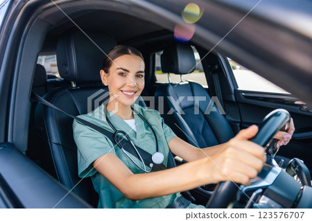 Smiling female doctor sitting in the car on a drivers seat 123576707
