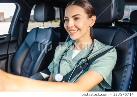 Smiling female doctor sitting in the car on a drivers seat Smiling female doctor sitting in the car on a drivers seat 123576714