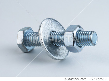 A metal screw and washer on a light surface 123577512