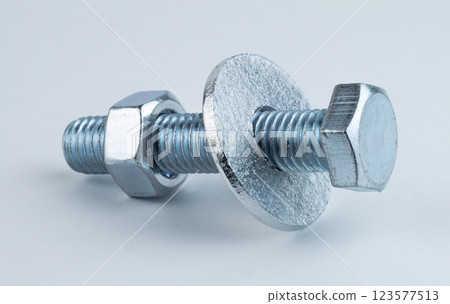 A metal screw and washer on a light surface 123577513