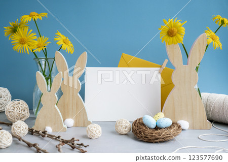 Empty white envelope mock up postcard greeting card copy space with bunny wooden figures and fresh flowers. Easter composition content still life. Christian symbols of spring 123577690
