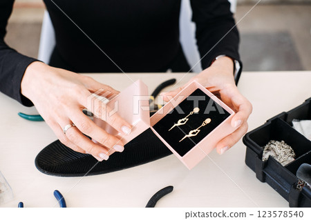 Elegant handmade earrings displayed in a jewelry gift box. Jewelry packaging, artisan branding, small business, luxury unboxing, product presentation, craft business 123578540