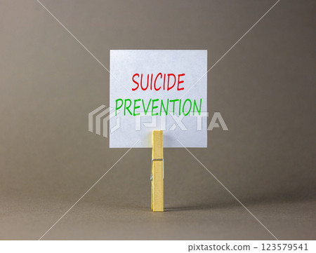 Suicide prevention symbol. Concept words Suicide prevention on beautiful white paper on clothespin. Beautiful grey table grey background. Psychological and suicide prevention concept. Copy space. 123579541