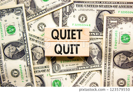 Quiet quit symbol. Concept words Quiet quit on wooden blocks. Beautiful background from dollar bills. Business and quiet quit concept. Copy space. Quiet quit symbol. Concept words Quiet quit on wooden blocks. Beautiful background from dollar bills. Business and quiet quit concept. Copy space. 123579550
