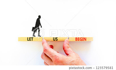 Let us begin symbol. Concept words Let us begin on beautiful wooden blocks. Beautiful white background. Businessman hand. Business motivational let us begin concept. Copy space. 123579581