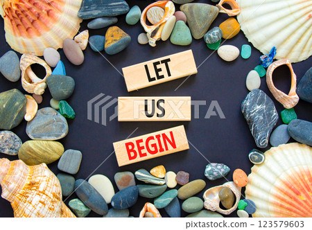 Let us begin symbol. Concept words Let us begin on beautiful wooden blocks. Beautiful black background. Sea shells and sea stones. Business motivational let us begin concept. Copy space. Let us begin symbol. Concept words Let us begin on beautiful wooden blocks. Beautiful black background. Sea shells and sea stones. Business motivational let us begin concept. Copy space. 123579603