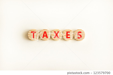 Taxes symbol. Concept word Taxes on beautiful wooden circles. Beautiful white table white background. Business lifestyle taxes concept. Copy space. 123579700
