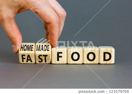 Fast or homemade food symbol. Concept words Fastfood or Homemade food on wooden cubes. Beautiful grey table grey background. Doctor hand. Healthy lifestyle Fast or homemade food concept. Copy space. 123579709