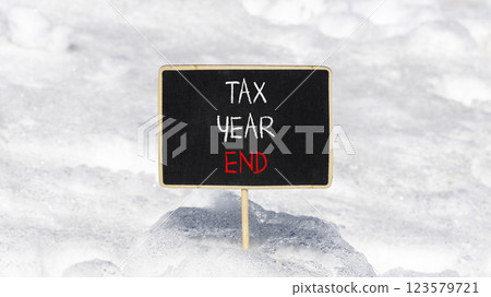 Tax year end symbol. Concept words Tax year end on beautiful black yellow blackboard. Beautiful white snow background. Business tax year end concept. Copy space. 123579721