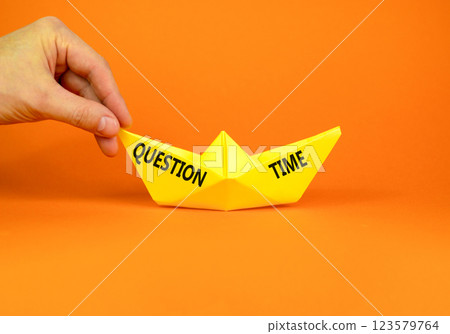 Question time symbol. Concept words Question time on beautiful yellow paper boat. Beautiful orange paper background. Businessmen hand. Business and question time concept. Copy space. 123579764