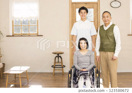 Care image: wife in wheelchair, husband and caregiver 123580672
