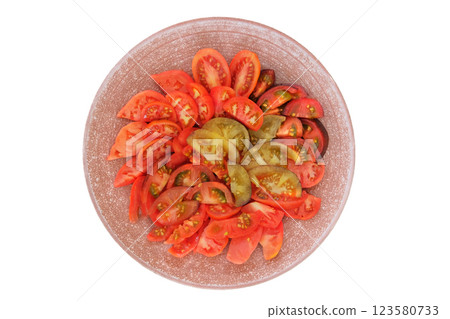 Tomatoes in a clay plate isolate on white background. Red sliced tomato in rustic red bowl. Food making. Top view. Tomatoes in a clay plate isolate on white background. Red sliced tomato in rustic red bowl. Food making. Top view. 123580733