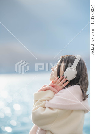 湖邊戴著耳機聽音樂的年輕女子 123580884