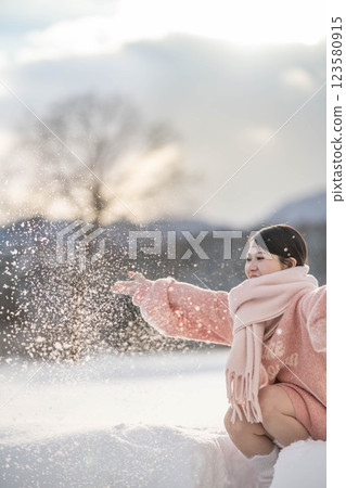 在溫暖的冬日陽光下,身穿針織服裝的年輕女子 在溫暖的冬日陽光下,身穿針織服裝的年輕女子 123580915