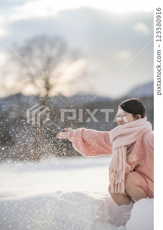 A young woman in a knitted outfit in the warm winter light 123580916