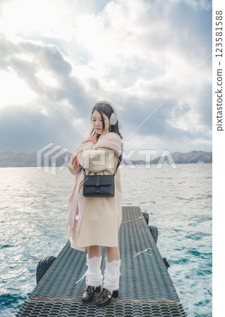 Young woman standing on a pier on a lake Young woman standing on a pier on a lake 123581588
