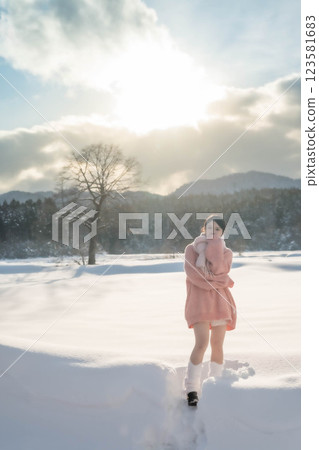 Girl walking in the snow in winter park 123581683