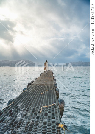 Young woman standing on a pier on a winter lake 123581739