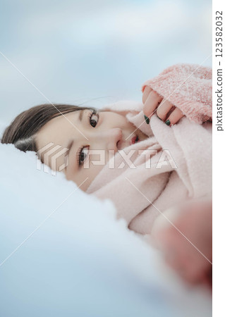 Young woman lying on the snow Young woman lying on the snow 123582032