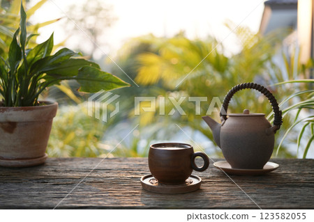 Old vintage Tea cup and earthenware teapot at the cozy garden, chilling outdoor relaxing Old vintage Tea cup and earthenware teapot at the cozy garden, chilling outdoor relaxing 123582055