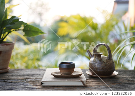 Old vintage Tea cup and earthenware teapot at the cozy garden, chilling outdoor relaxing Old vintage Tea cup and earthenware teapot at the cozy garden, chilling outdoor relaxing 123582056
