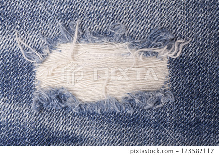 Closeup detail of torn on blue jeans. Denim jeans texture. Closeup detail of torn on blue jeans. Denim jeans texture. 123582117
