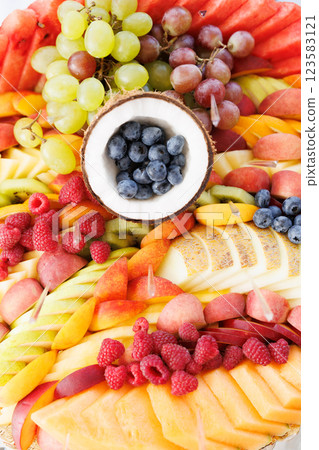 Colorful fruit platter featuring blueberries in coconut shell, raspberries, grapes, and sliced melon Colorful fruit platter featuring blueberries in coconut shell, raspberries, grapes, and sliced melon 123583121