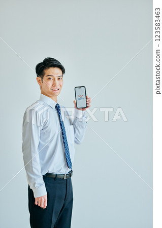 A young man in his 20s holding a smartphone NISAvsiDeCo A young man in his 20s holding a smartphone NISAvsiDeCo 123583463