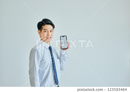 A young man in his 20s holding a smartphone NISAvsiDeCo 123583464