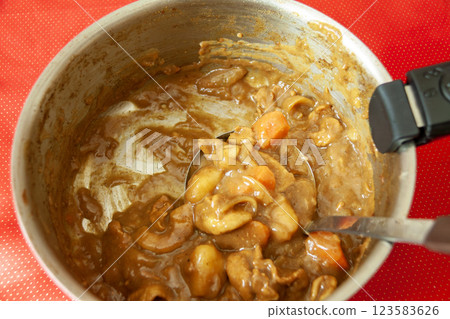 The bottom of the pot is visible, with only a little curry left 123583626