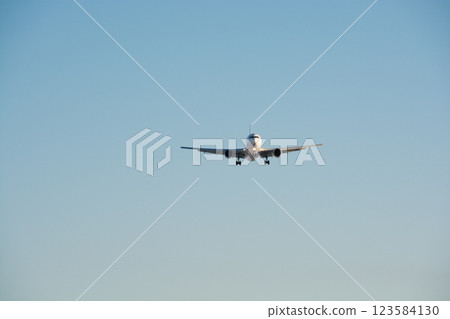 An airplane preparing to land reflecting the sunlight An airplane preparing to land reflecting the sunlight 123584130