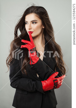 Pretty fashionable woman with make-up and dark hair wearing red leather gloves  123584271
