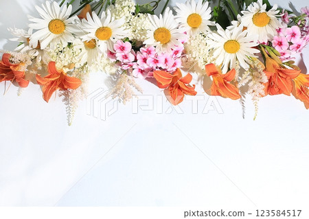 Abstract floral composition, background, holiday concept with flowers, spring and summer banner. Chamomile flowers, lilies and phlox on a sunny table, postcard with space for text. selective focus 123584517