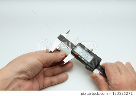 雙手使用數位卡尺測量螺栓的長度 123585271