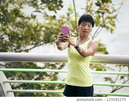 young asian woman taking a selfie outdoors 123585275