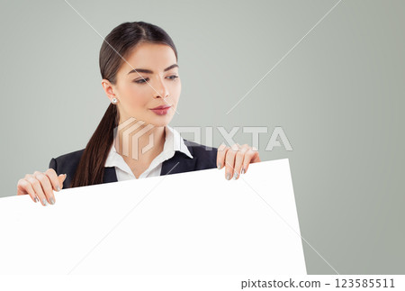 Young business woman holding white empty paper banner background with copy space indoor 123585511