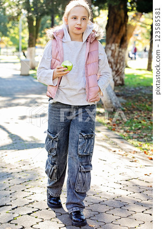 Pretty child girl walking in city park outdoors. Healthy playful kid portrait 123585581
