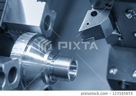 The CNC lathe machine forming cutting the metal shaft parts in the light blue scene. The CNC lathe machine forming cutting the metal shaft parts in the light blue scene. 123585655