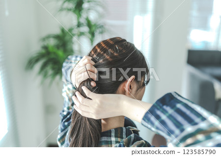 一位女士綁頭髮的背影 123585790