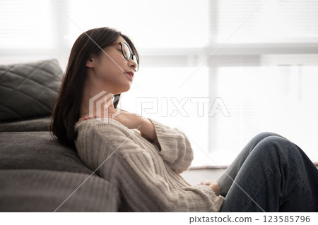 Woman with glasses putting her hand on her shoulder 123585796