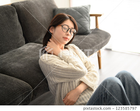 A woman with her hands on her neck, relaxing 123585797