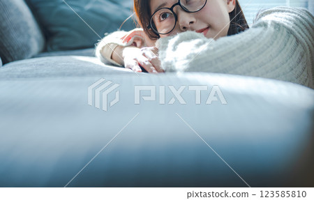 戴眼鏡的女人在沙發上放鬆 123585810