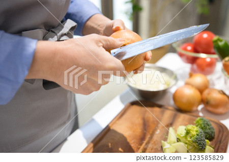 Hands of a middle-aged woman cutting vegetables 123585829