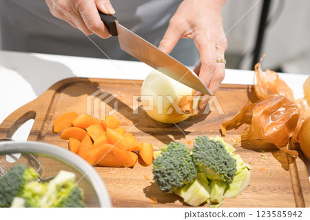 Hands of a middle-aged woman cutting vegetables 123585942