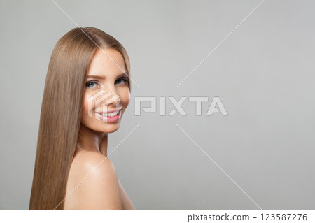 Glad young woman model with modern make-up and long straight smooth hairstyle standing Glad young woman model with modern make-up and long straight smooth hairstyle standing 123587276