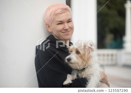 Healthy woman having fun playing with pet dog outdoors 123587290